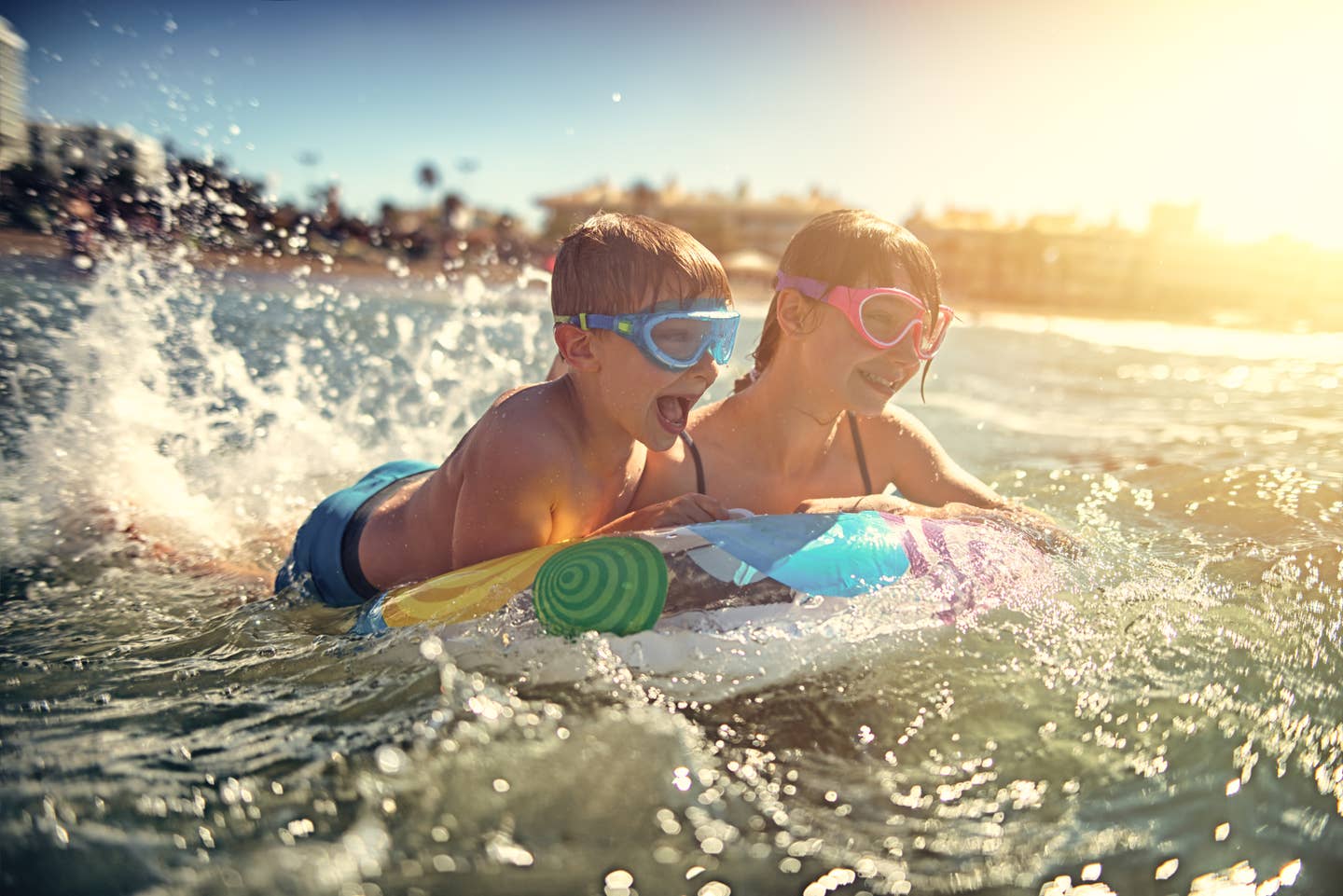 Familienurlaub Spanien: Kinder planschen im Wasser an einem Strand auf Mallorca.