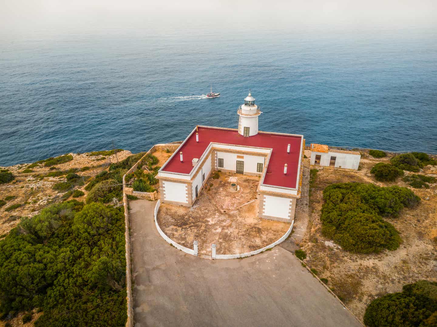 Klassisch mallorquinischer Leuchtturm in Rot und Weiß aus der Vogelperspektive zu sehen