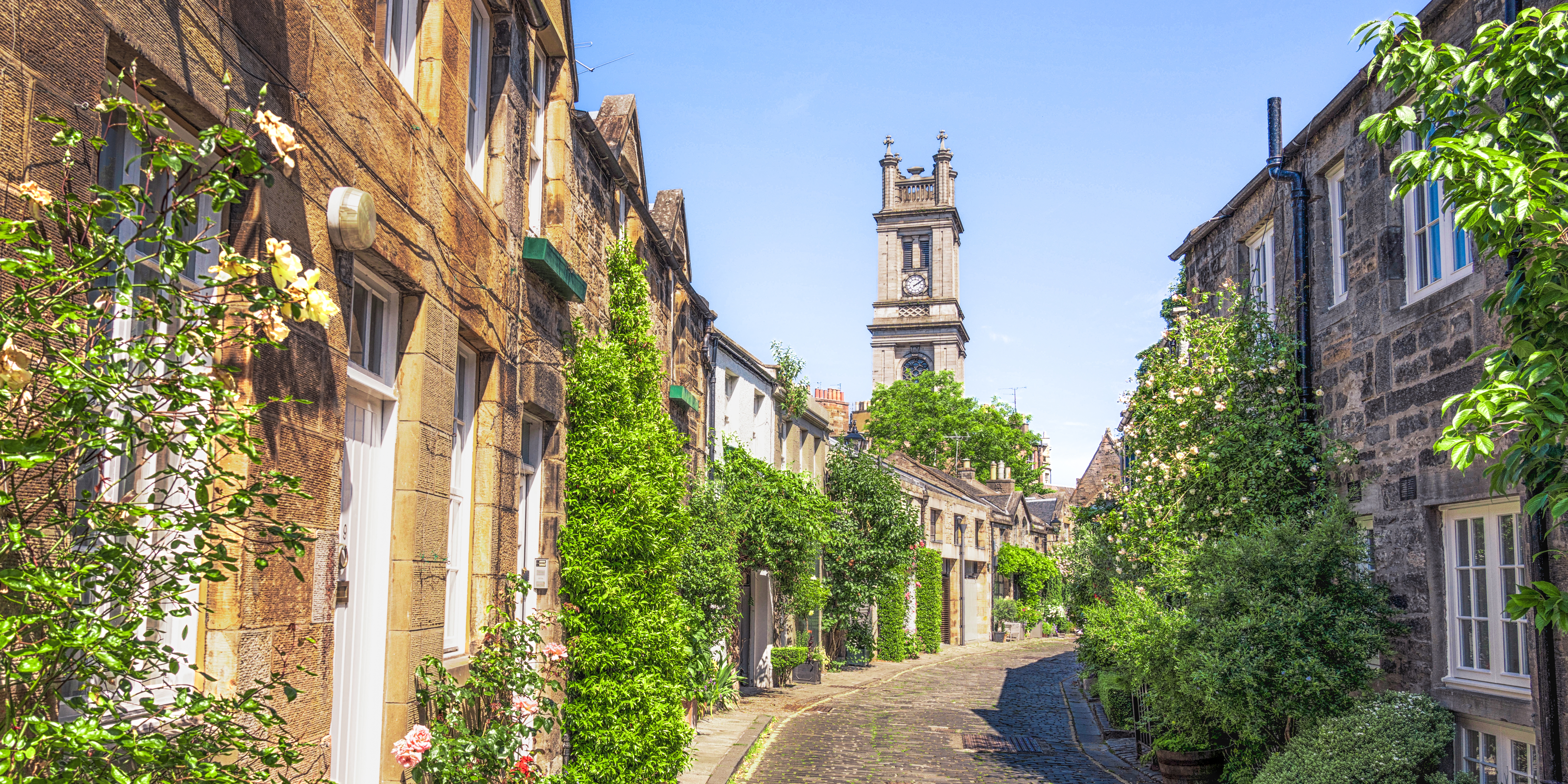 Deine BookTok-Reise strahlt mit einer charmanten Straße in Edinburgh mit alten Steingebäuden die grün bewachsen ist