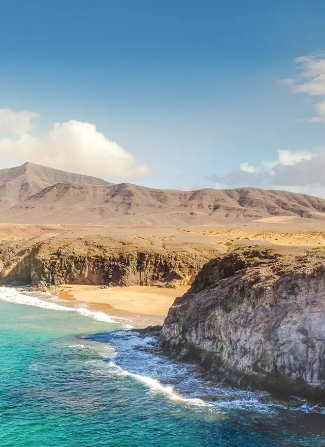 Jetzt entdecken Kanaren-Urlaub: Strand mit Blick auf die Berge