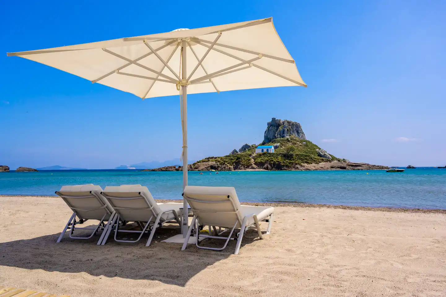 Kos Hotel All Inclusive: Liegestuhl und Sonnenschirm am Strand von Agios Stefanos