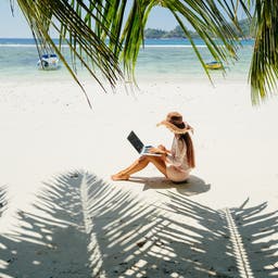 frau-arbeitet-am-strand-palmen-g-1217053906-beratung-und-kontakt.jpg