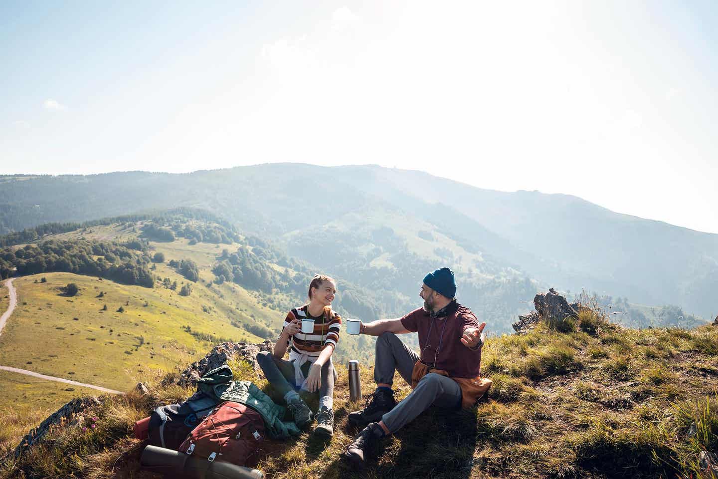 Wanderer-Paar stößt vor Bergpanorama an