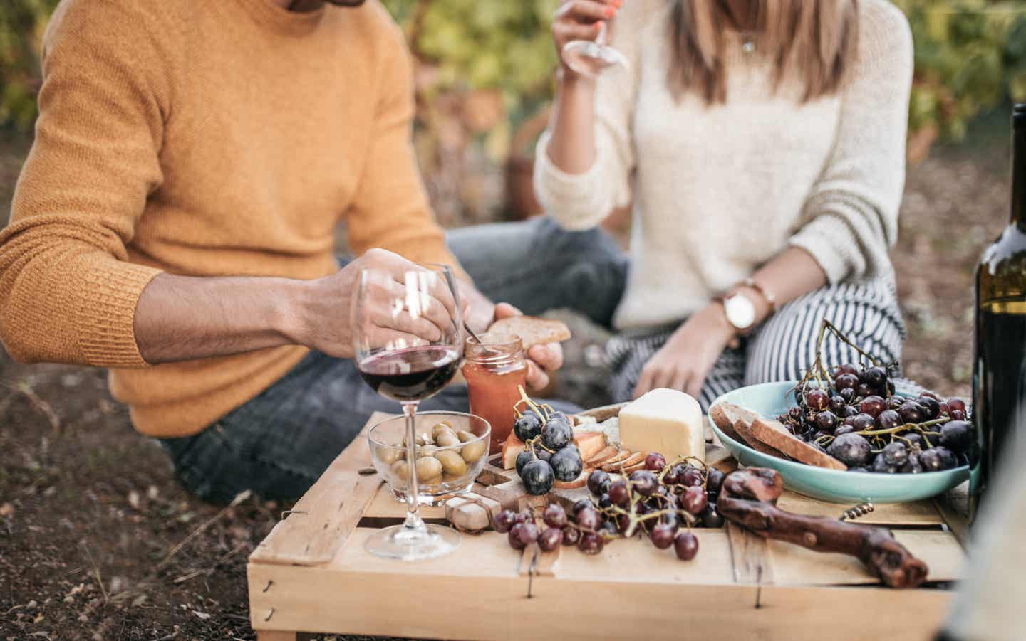 Apulien Urlaub mit DERTOUR. Paar beim Picknick in einem Weinberg