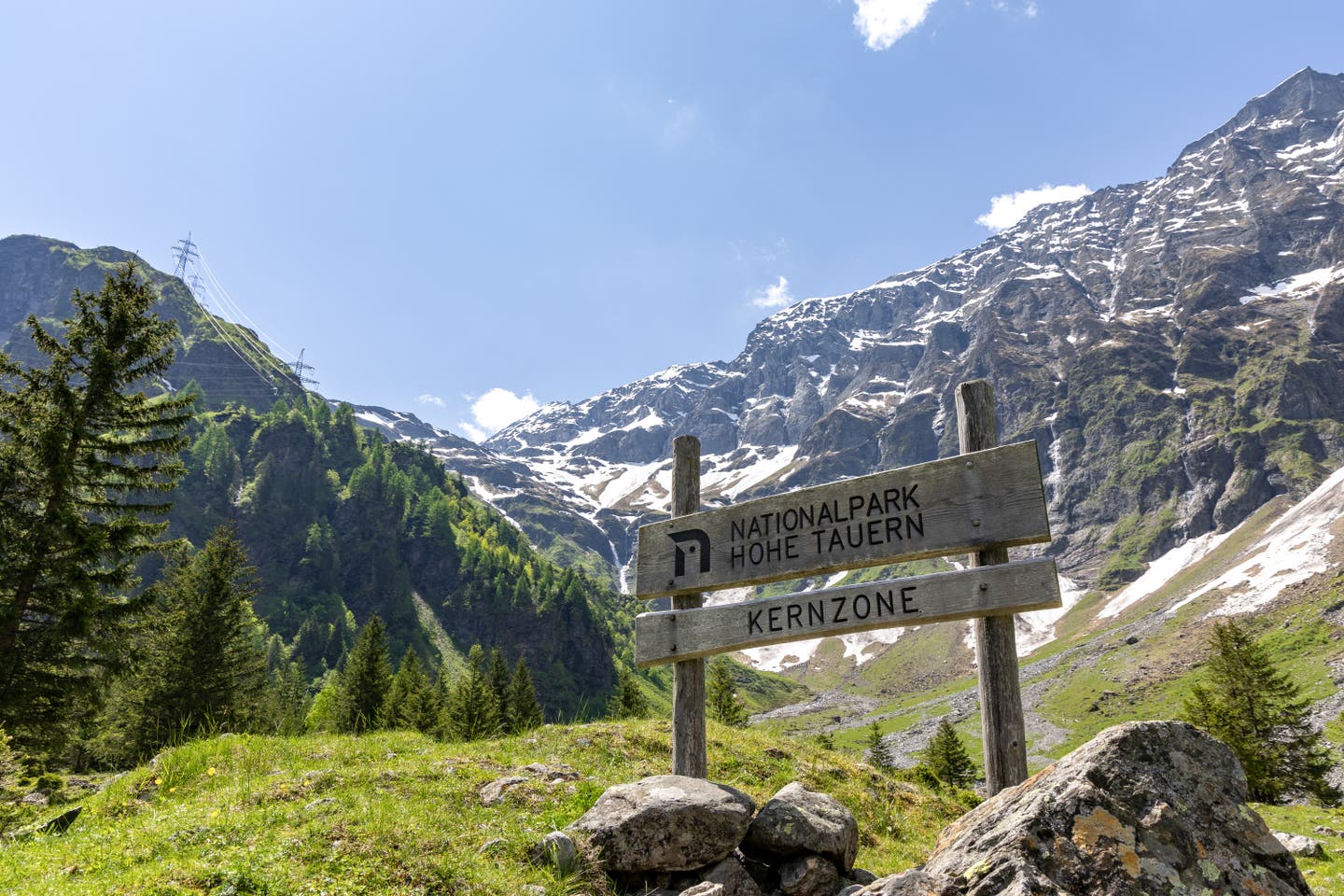 Holzschild, Eingang zum Nationalpark Hohe Tauern in Österreich mit Bergen im Hintergrund