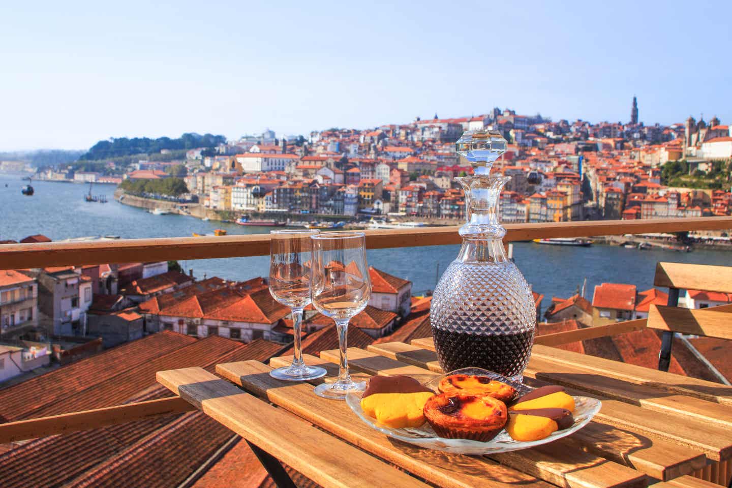 Porto steht für Portwein und Pastel de Nata Gedeckter Tisch mit einer Karaffe Portwein und Süßspeise Pastel de Nata