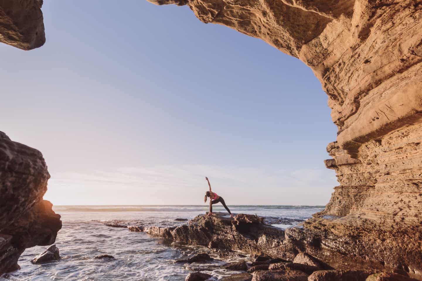 Frau macht Yoga am Meer