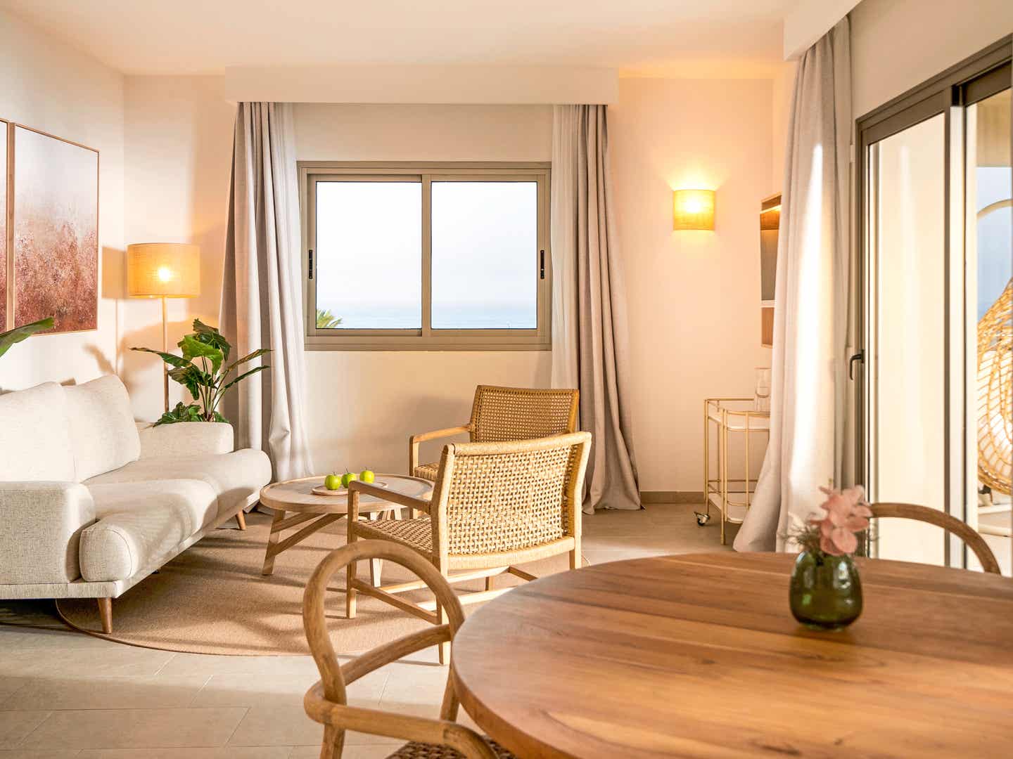 Helles Familienzimmer im Iberostar Waves Gaviotas Park mit Sofa, Holzmöbeln und Blick auf das Meer