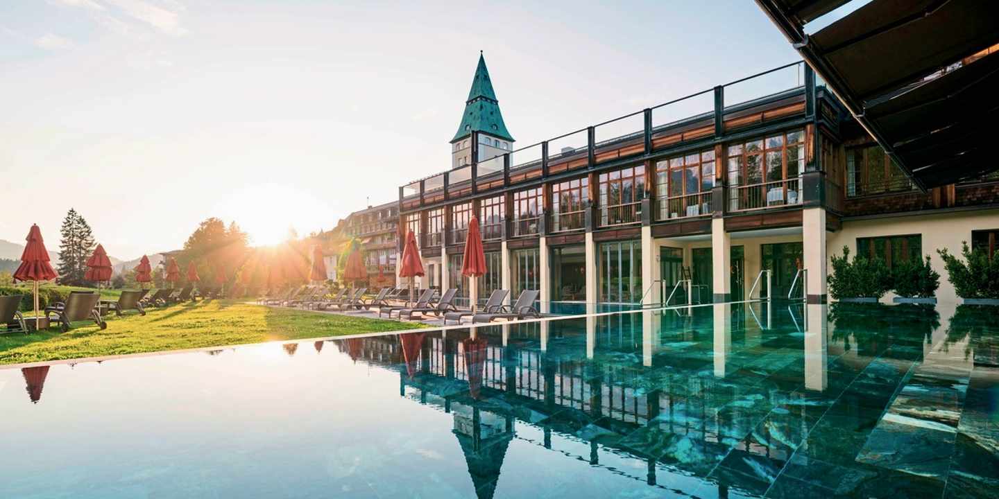 Blick auf den Außenpool des Schloss Elmau Luxury Spa Retreat & Cultural Hideaway in der Abenddämmerung