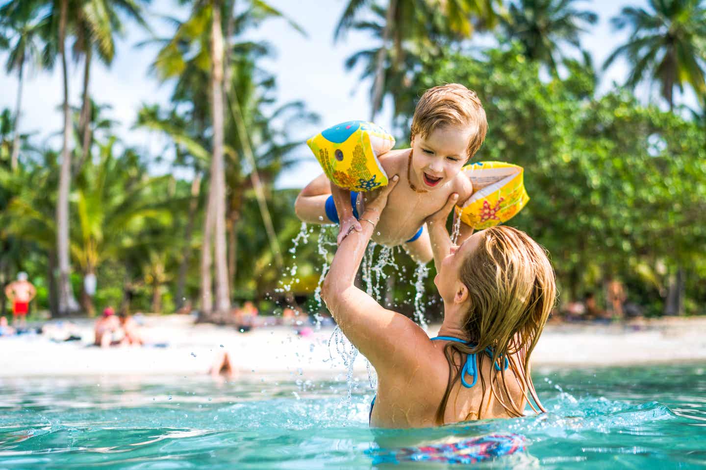 Mutter mit Kind im Wasser am Strand von Pattaya