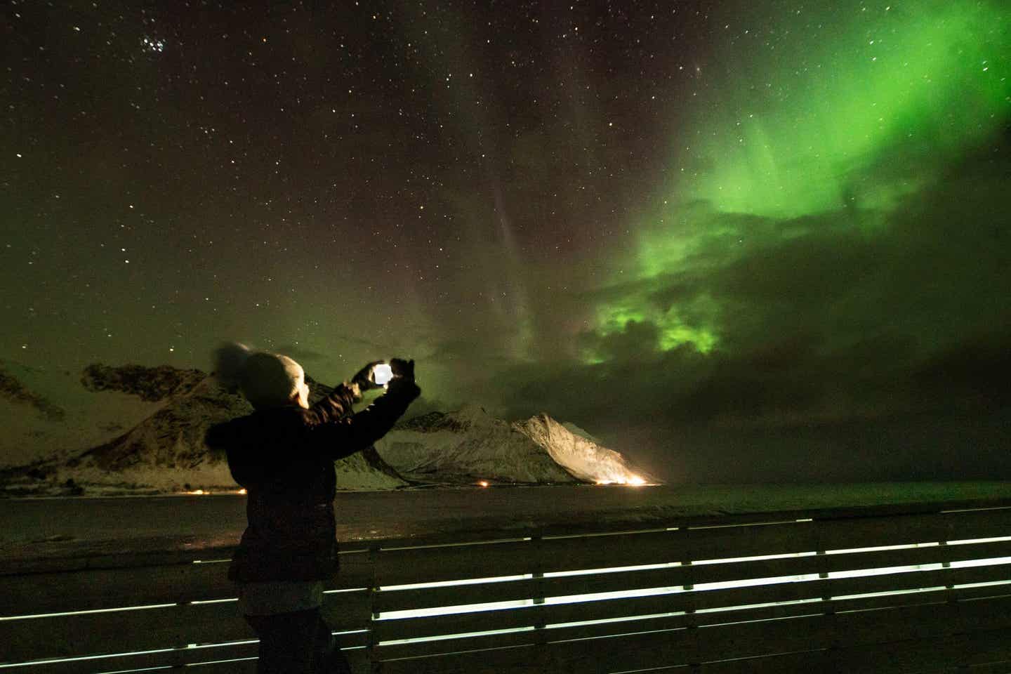 Nordlichter sehen und fotografieren: Frau mit Smartphone