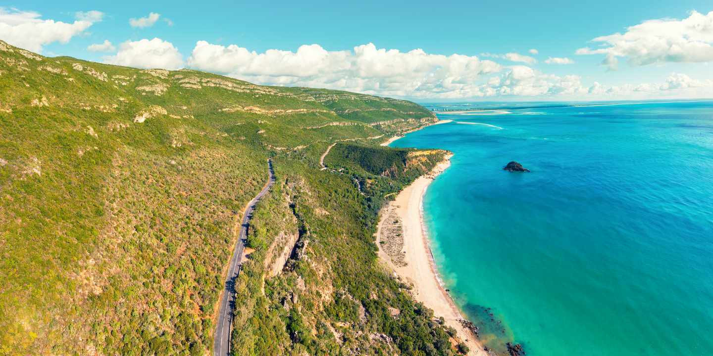 Naturwunder Portugals: Bucht Portinho da Arrábida bei Setúbal mit türkisfarbenem Wasser, Küstenstraße und grünen Hängen