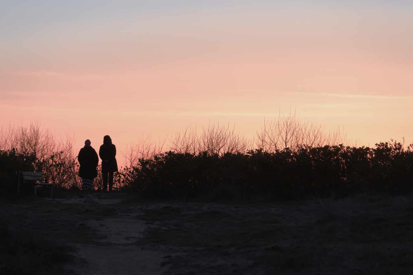 Mecklenburg Vorpommern Urlaub mit DERTOUR. Silhouette eines Paars am Strand von Rügen bei Sonnenuntergang