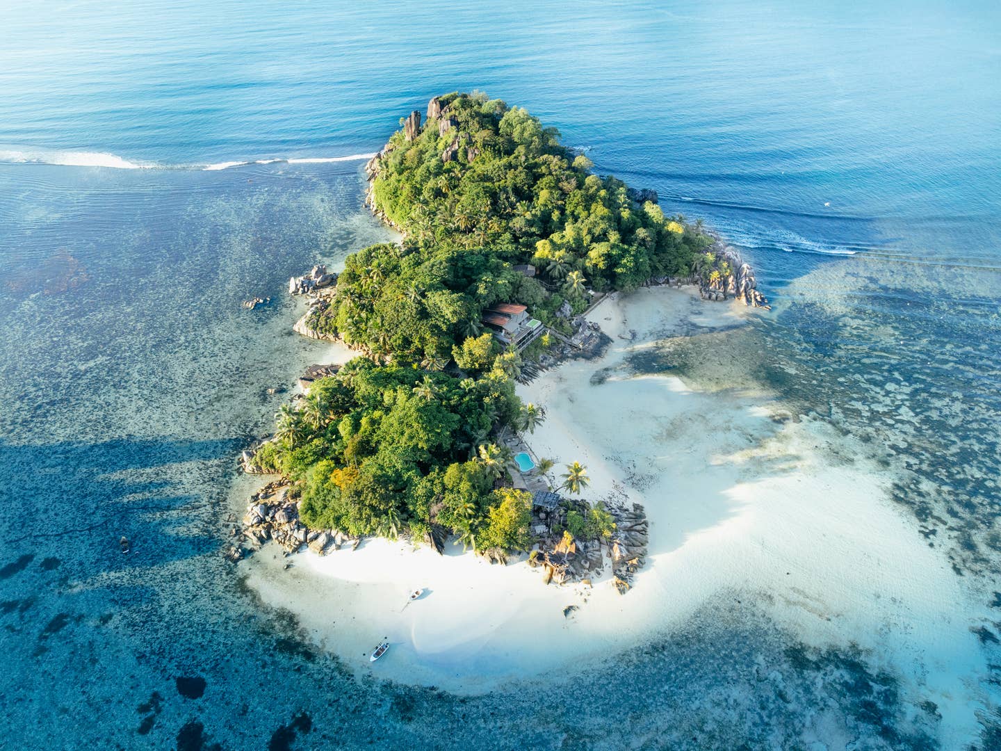 Blick auf das Constance Ephelia Resort auf den Seychellen, das auf einer kleinen grünen Insel auf einem Korallenriff liegt Blick auf das Constance Ephelia Resort auf den Seychellen, das auf einer kleinen grünen Insel auf einem Korallenriff liegt