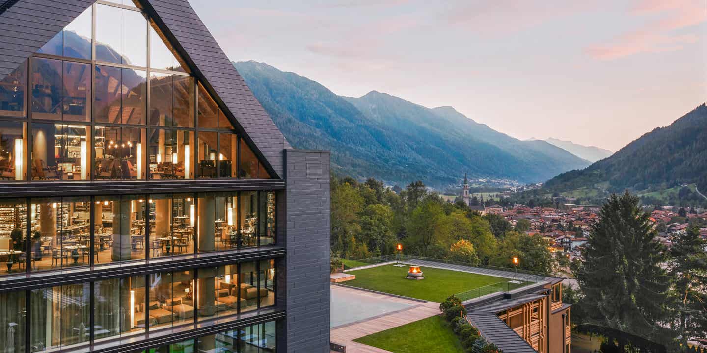 Blick auf die Berge der Dolomiten mit einem Terra Futura Hotel im Vordergrund aus Holz und Glas