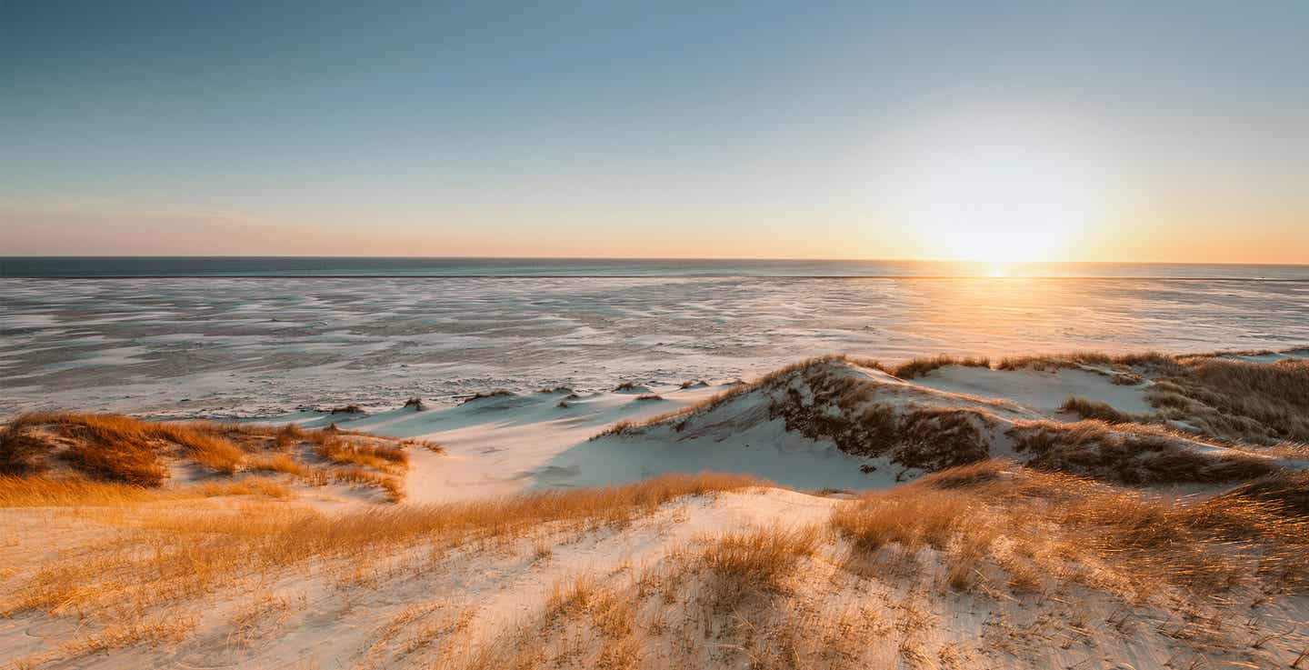 Die Küste von Amrum mit Sonnenuntergang am Wattenmeer – ein romantisches Ziel für einen Urlaub in Deutschland