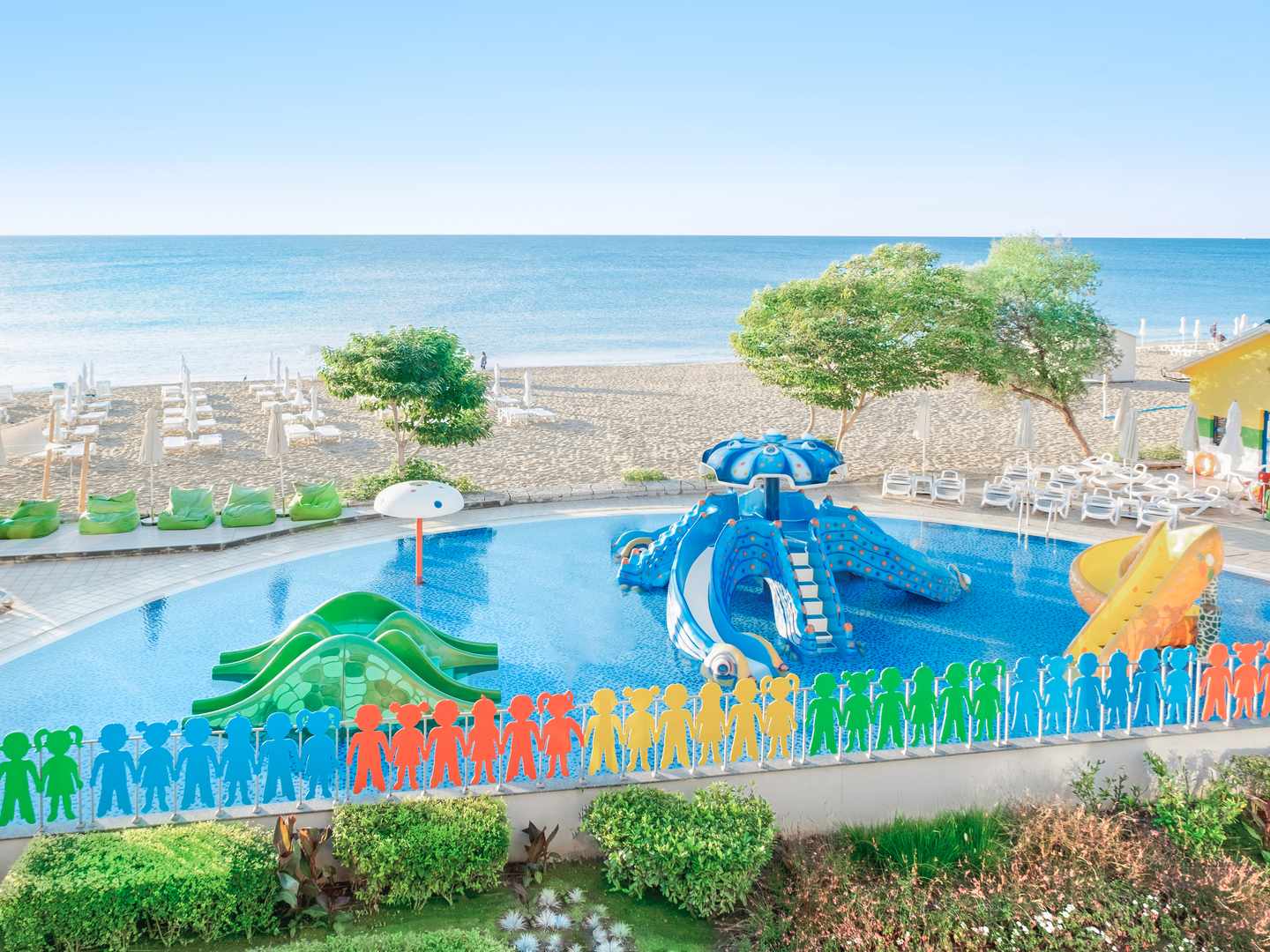 Blick auf Kinderpool mit Rutsche vor dem Strand