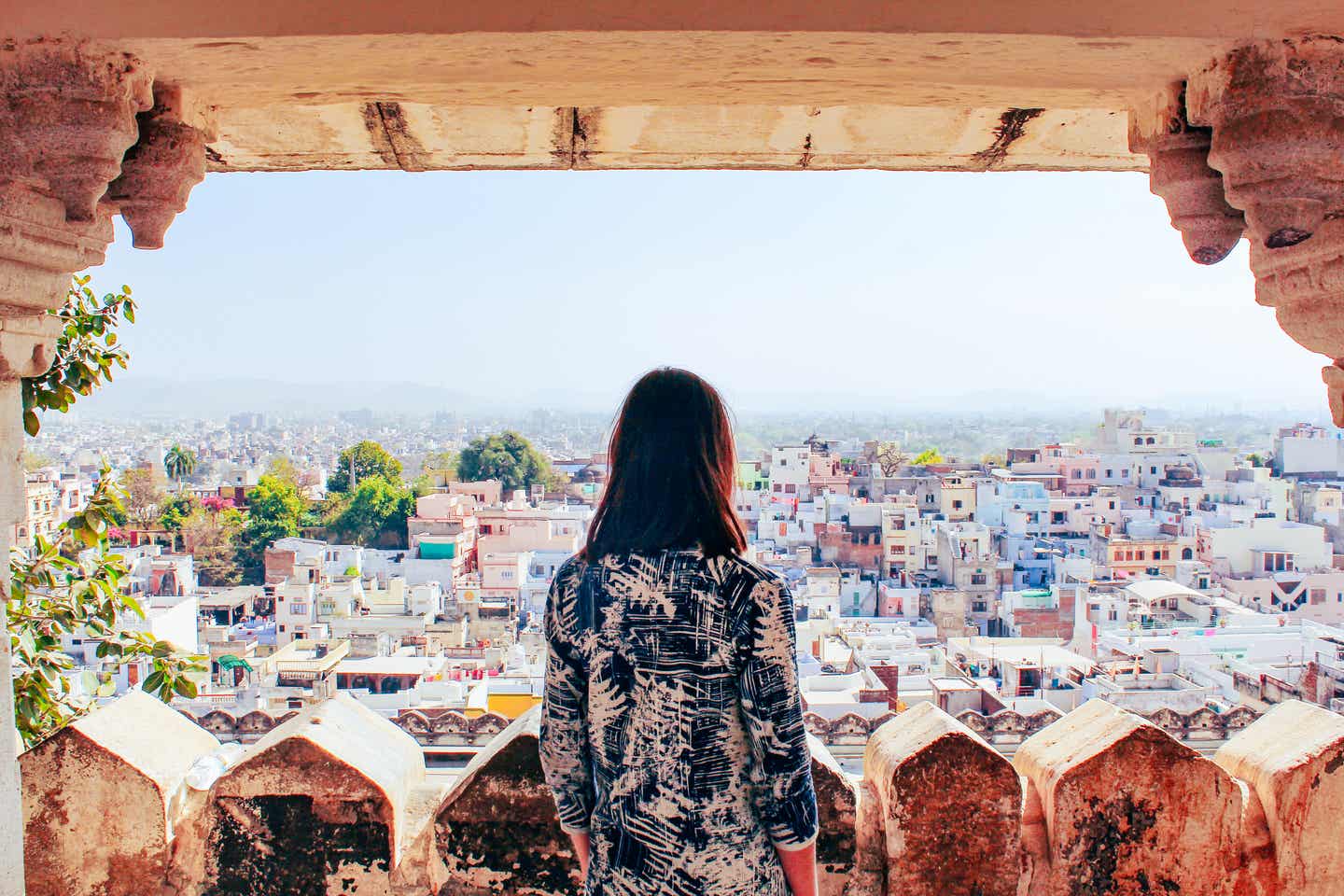 Frau schaut auf die Stadt Udaipur