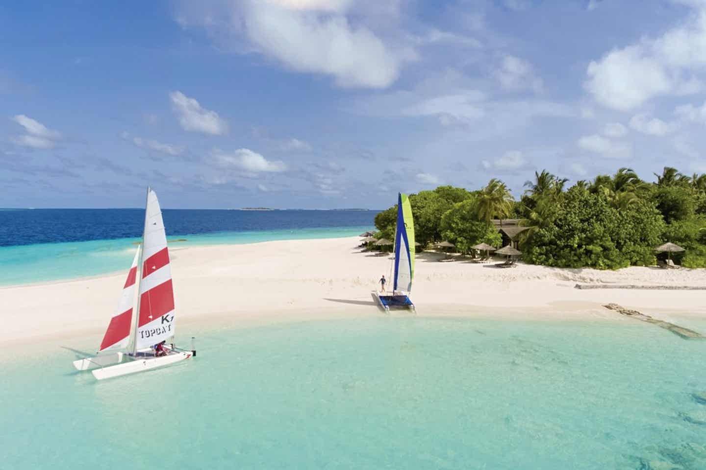 Zwei Katamarane halten auf einer tropischen Insel, die im türkisblauen Meer liegt