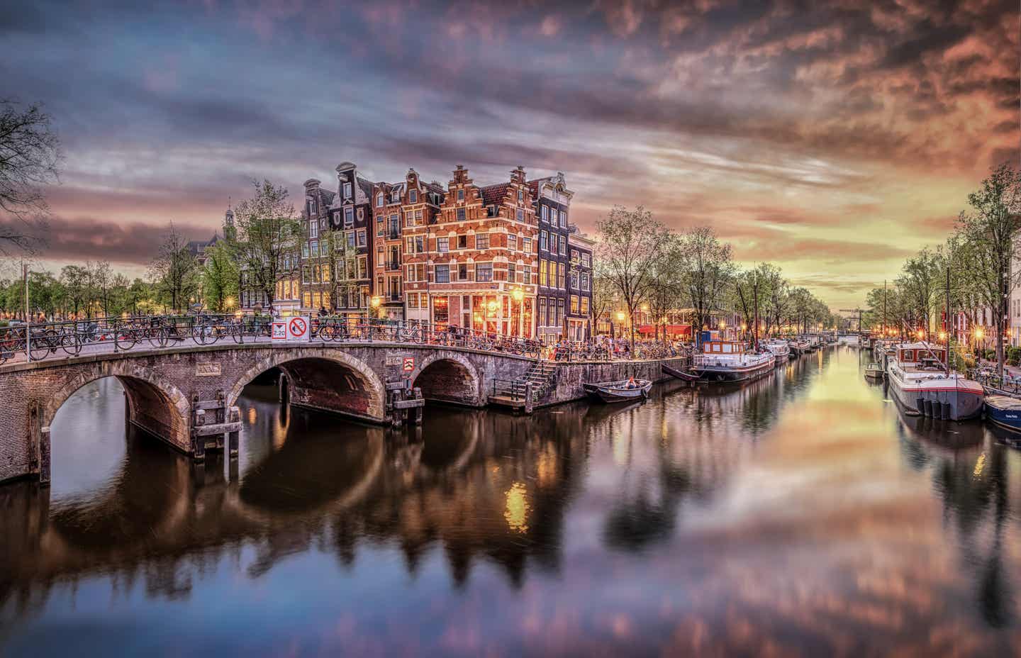 Niederlande Urlaub mit DERTOUR. Gracht und historische Häuser in Amsterdam