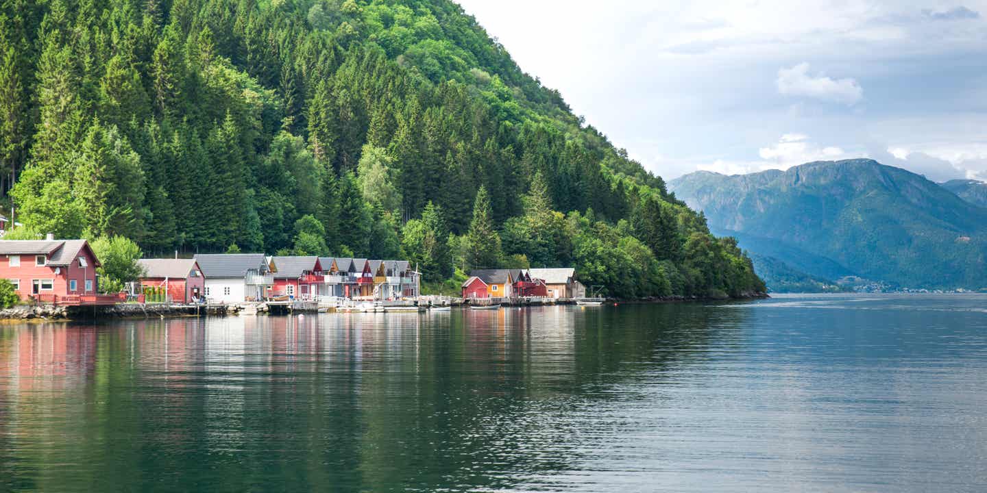 Eine iyllsche Landschaft: Häuserreihe zwischen Wald und Wasser des Sognefjords