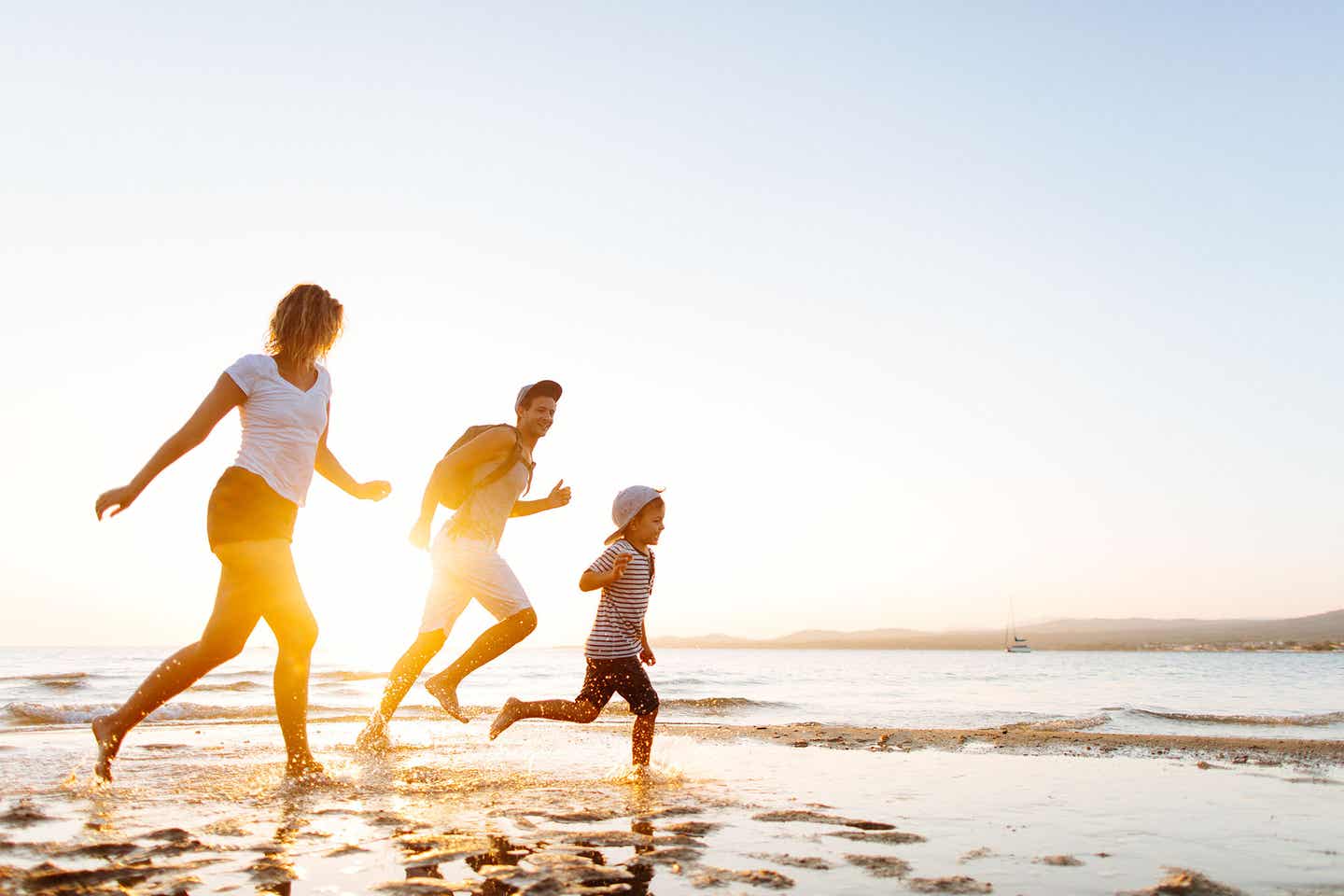 Rhodos Urlaub mit DERTOUR. Familie läuft am Strand entlang