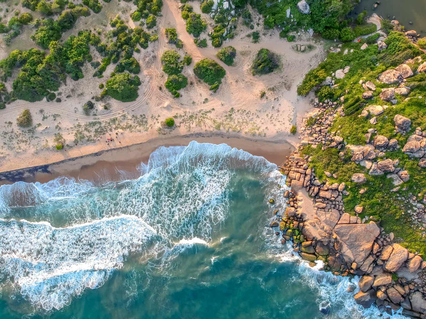 Tropischer Strand in Arugam Bay, umgeben von Felsen und Wellen – ein malerisches Ziel unter den Sri-Lanka-Sehenswürdigkeiten