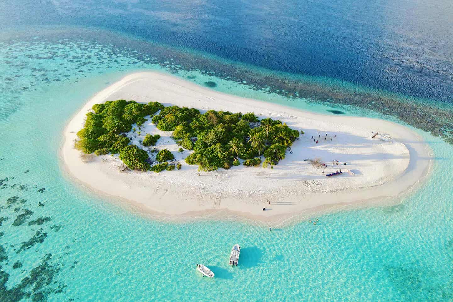 Unbewohnte Malediveninsel mit grüner Vegetation im türkisblauen Meer