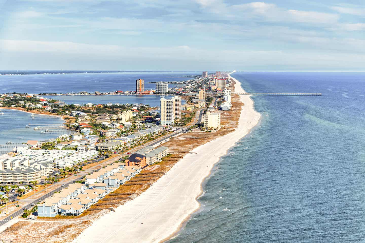 Hubschrauberaufnahme der Küste des Pensacola Beach und der dahinterliegenden Stadt in Florida