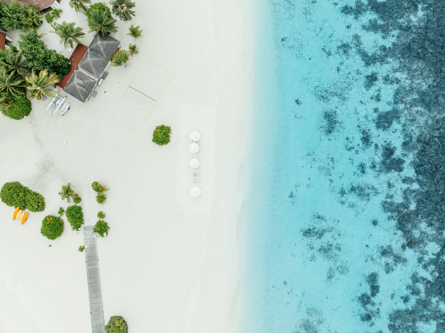 Top-Shot einer Drohne auf den weißen Hotelstrand und klares türkises Meer