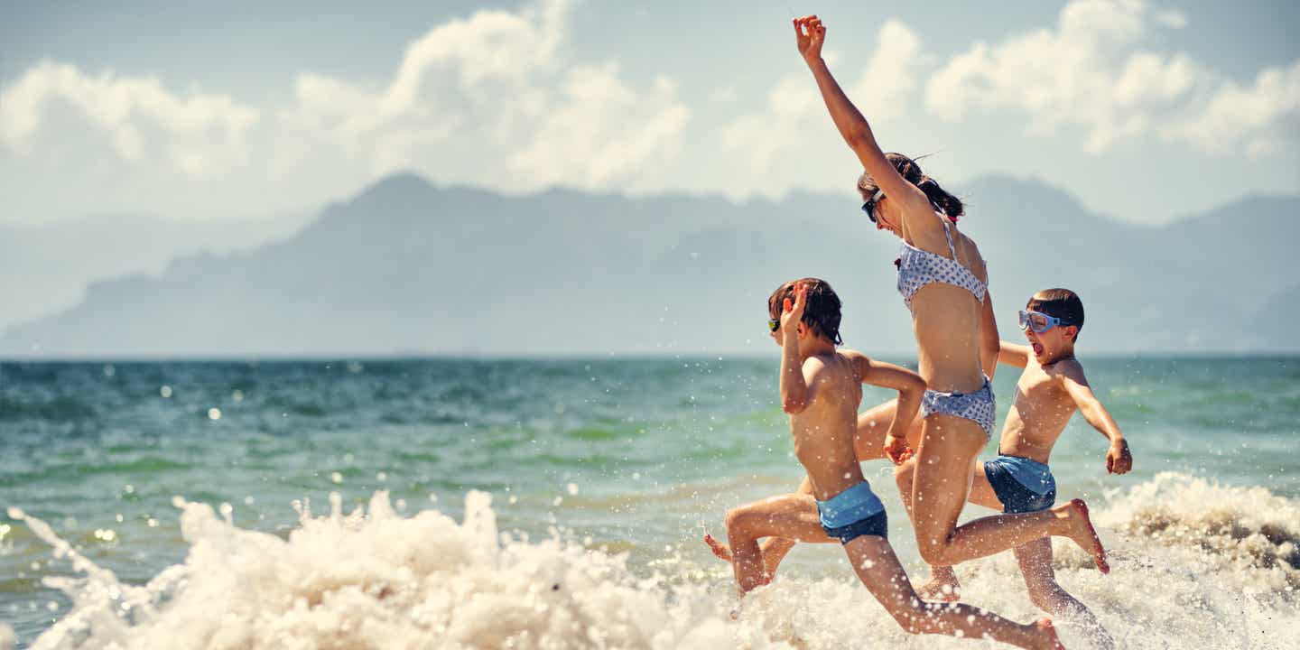 Kinder toben im Meer bei Sorrent in Kampanien, Italien nahe der Amalfiküste