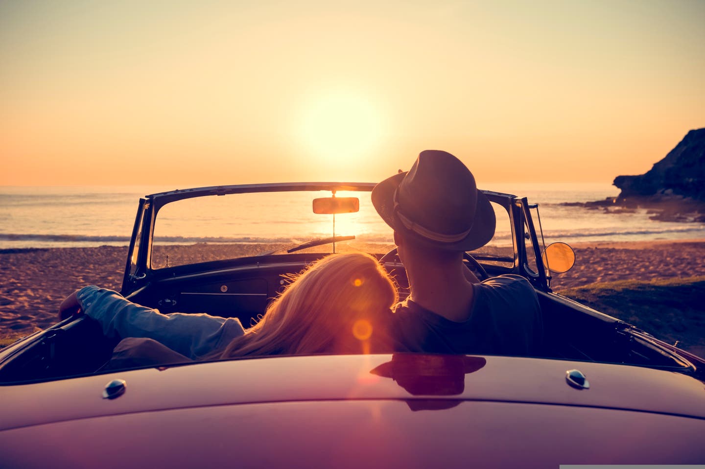 Paar im Cabrio am Strand