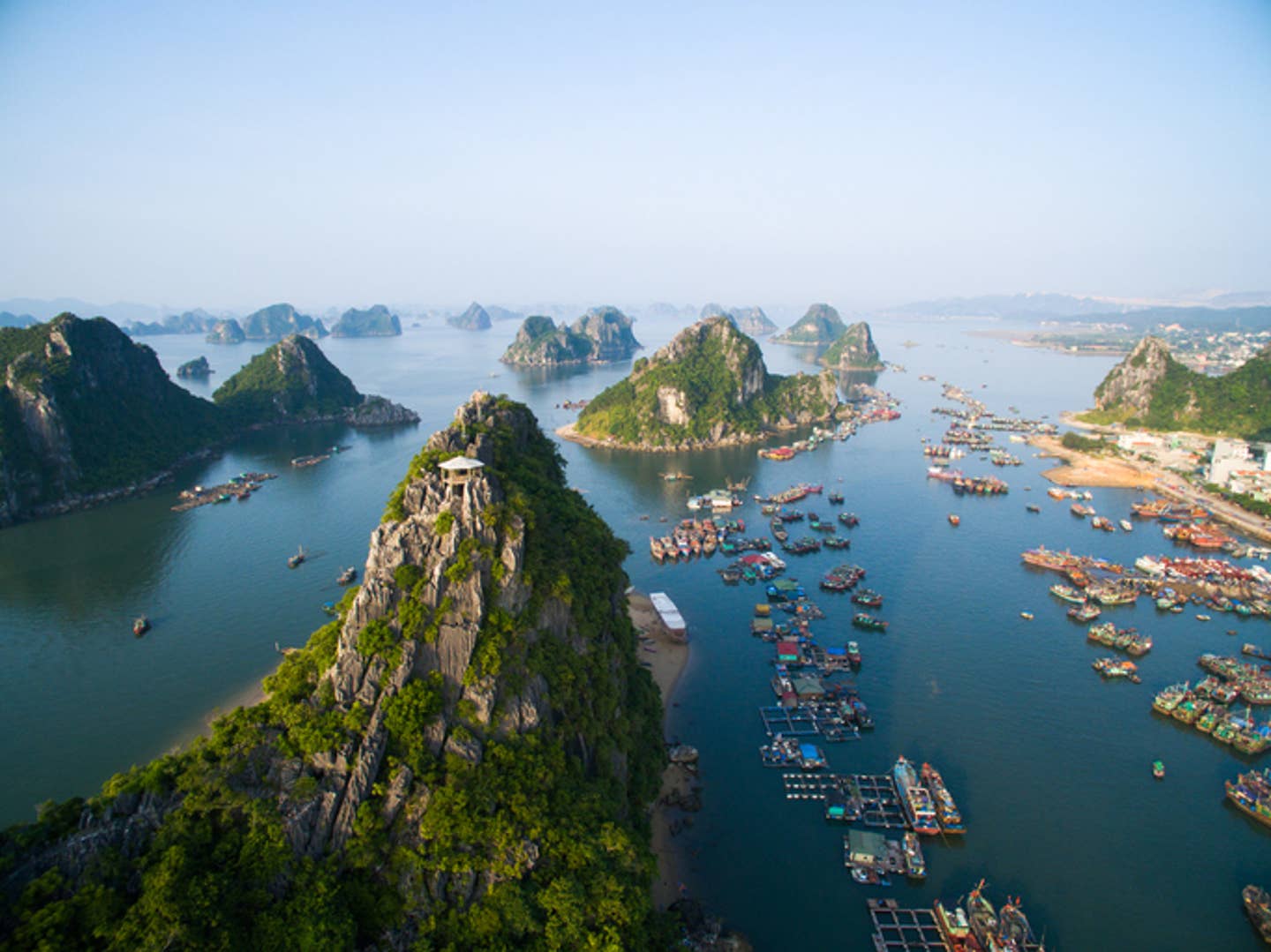 Rundreisen Vietnam: die Halong-Bucht in Vietnam umgeben von dicht bewaldeten Hügeln