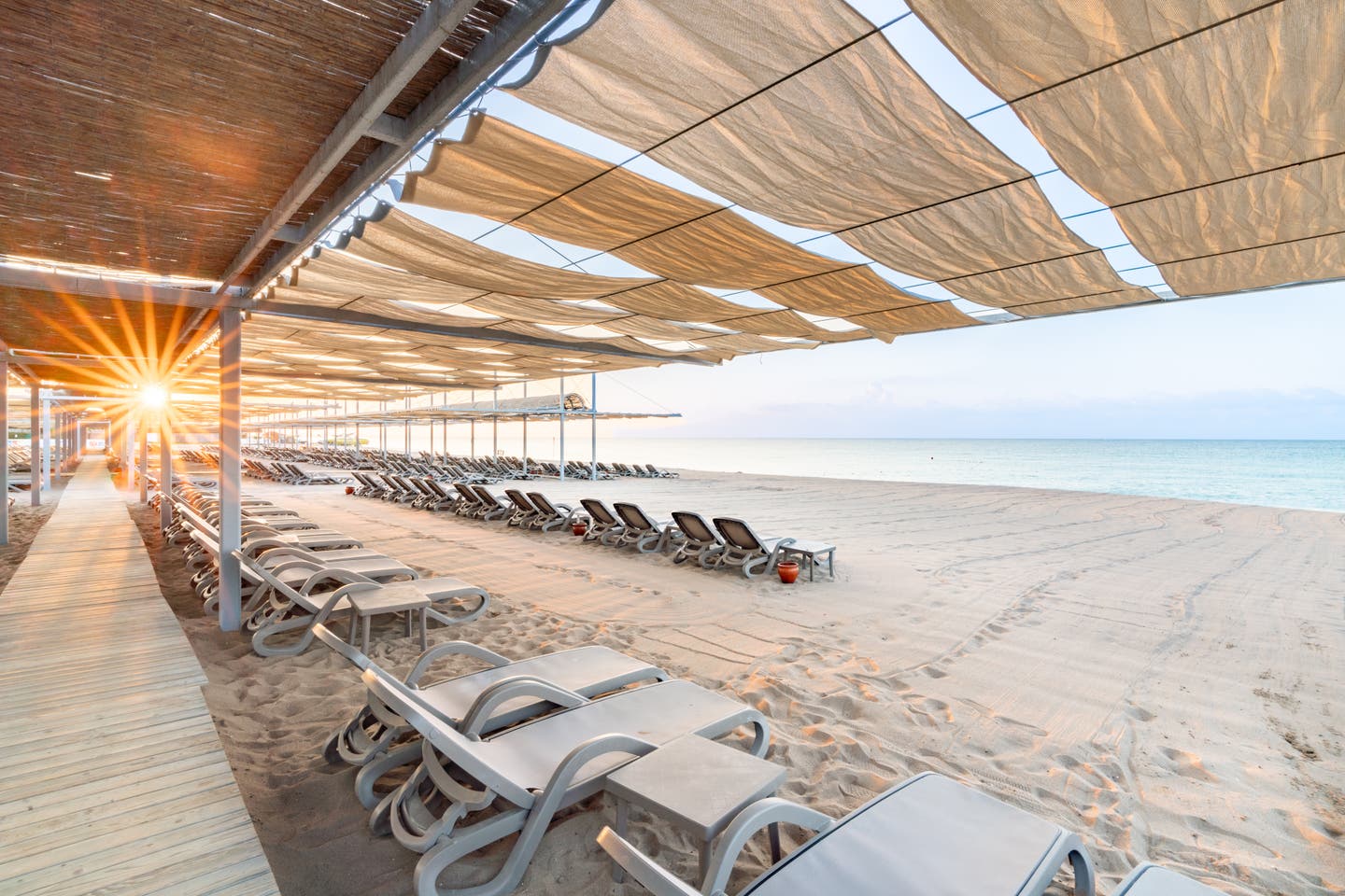 Holzplanken und Liegestühle auf dem Strand