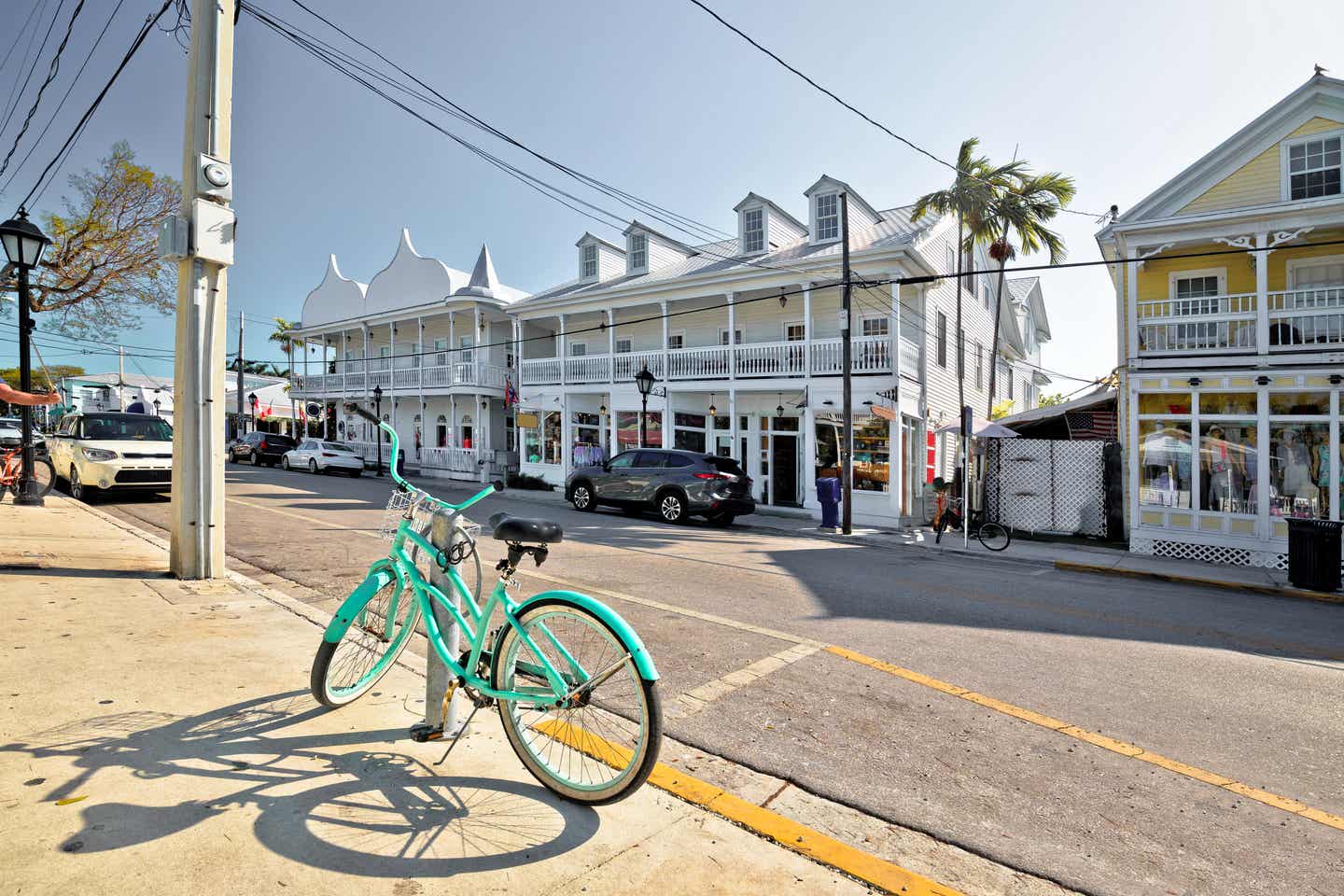 Ein türkisfarbenes Fahrrad steht im Key West Urlaub an einem sonnigen Tag auf der Duval Street