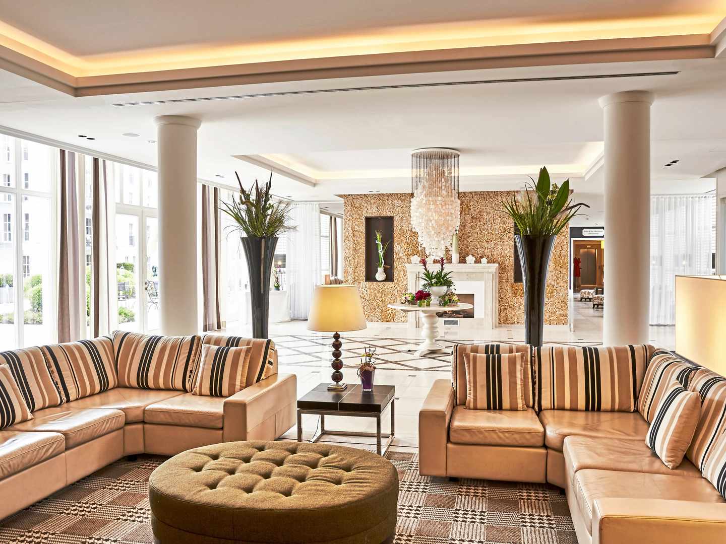 Offene Lobby mit viel Platz und Sitzbereichen – gut geeignet für kurze Pausen oder Treffen vor Ausflügen Lobby im Steigenberger Grandhotel & SPA Heringsdorf mit Sitzbereich, Kamin und großen Fensterfronten