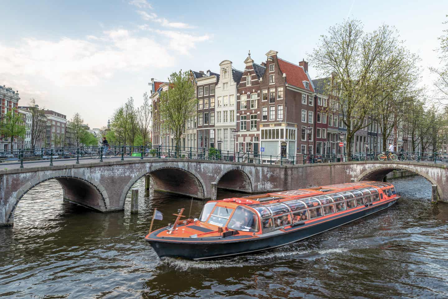 Amsterdam Geheimtipps: Boot fährt durch Kanal in Amsterdam