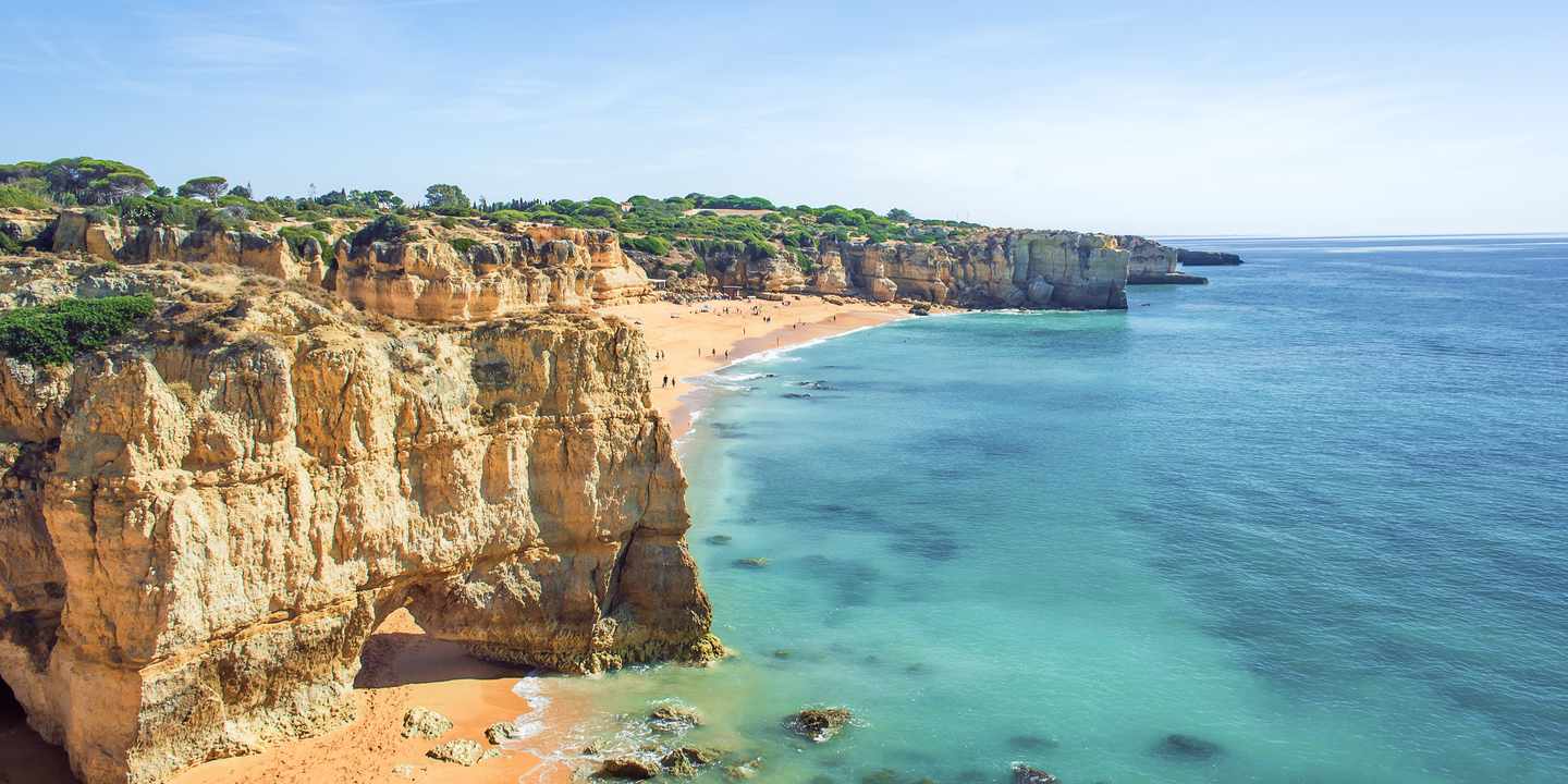 Praia Dona Ana bei Lagos mit goldenen Felsklippen, türkisfarbenem Wasser und Sandstrand an der Algarve