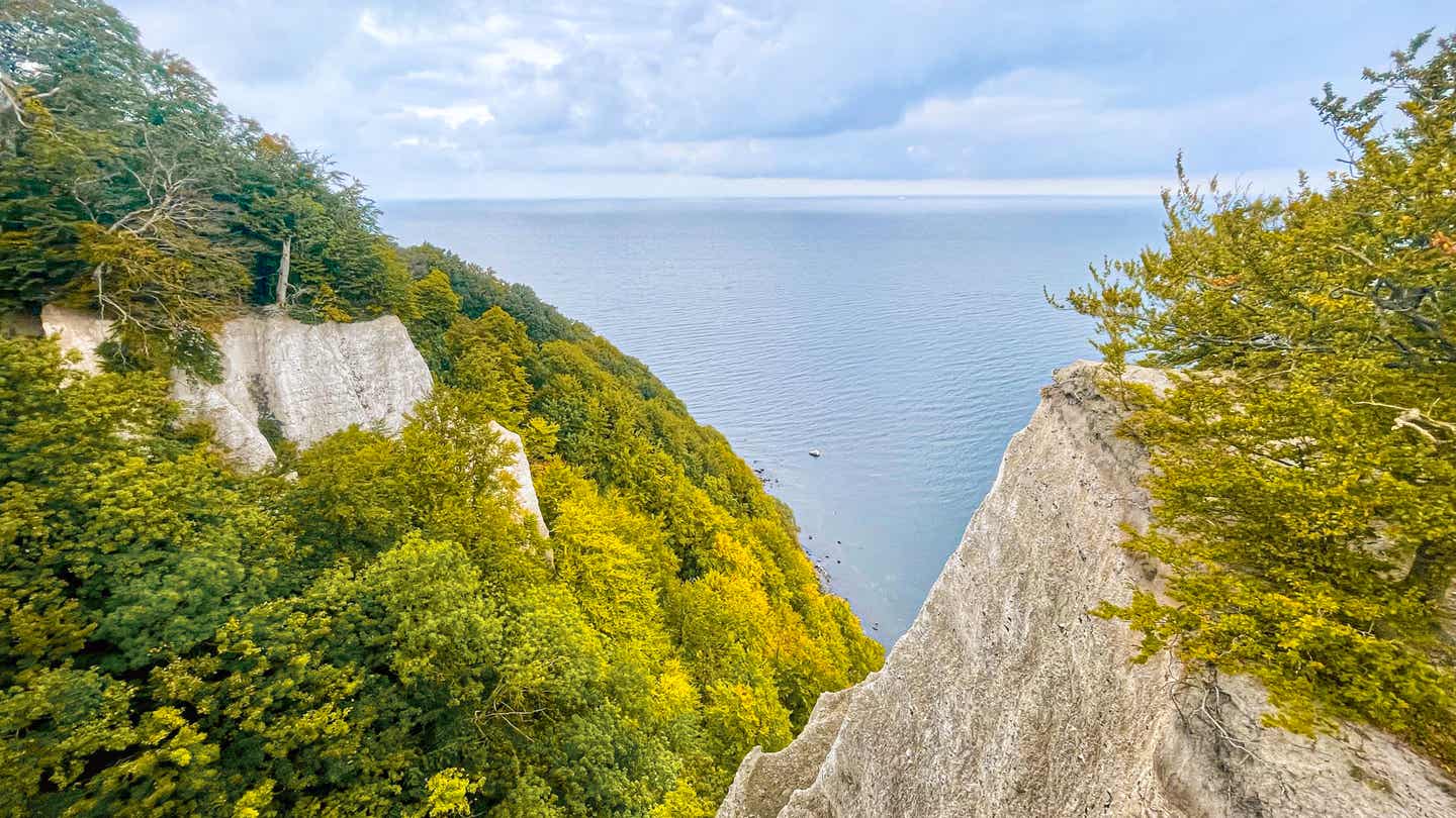 Blick von der Aussichtsplattform Skywalk Königsstuhl auf Rügen über weiße die Kreidefelsen, grüne Buchenwälder und die blaue Ostsee  