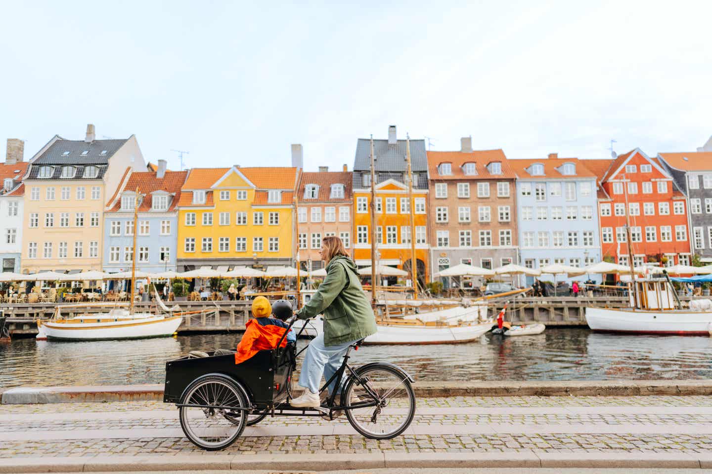 Städtetrip September. Dänemark: Mutter mit Söhnen auf Lastenrad in Kopenhagen