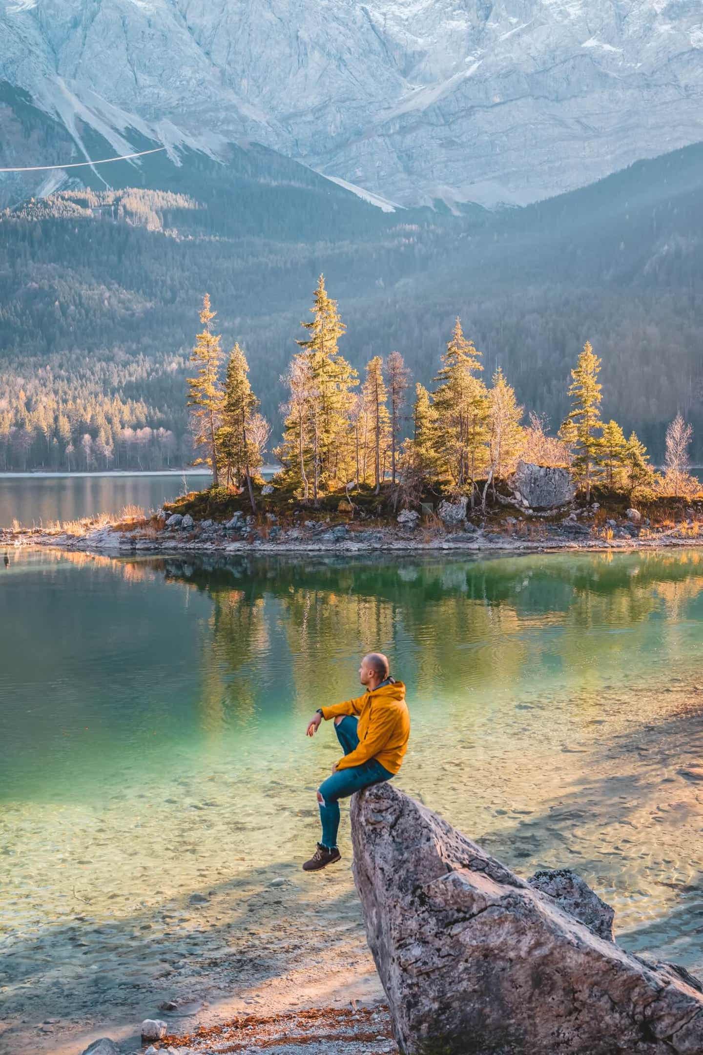 Tolles Fotomotiv: Mann auf einem Felsen vor dem Eibsee