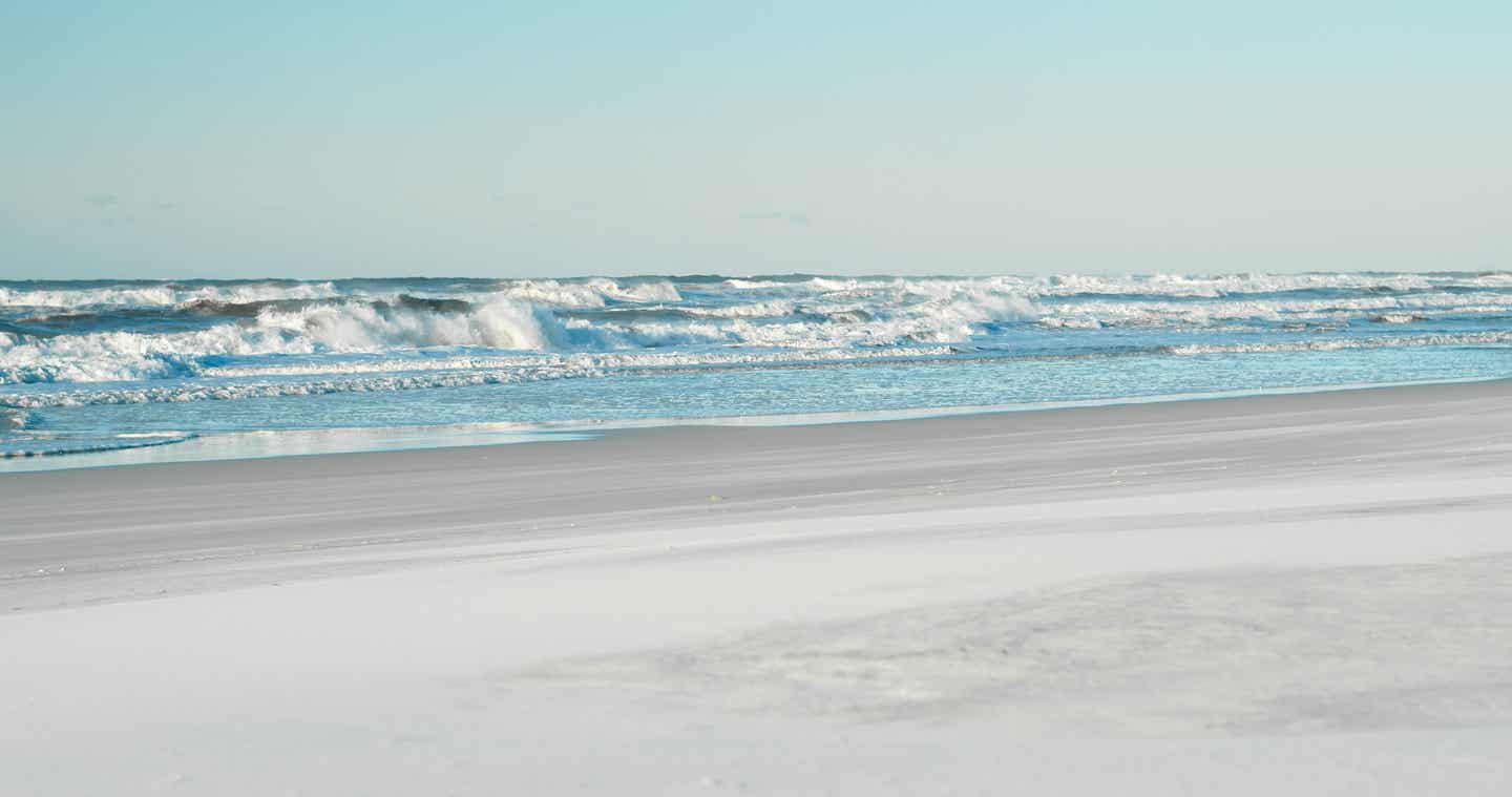 Wild tosende Wellen, die im Morgenlicht auf den Sand von Grayton Beach Florida rauschen