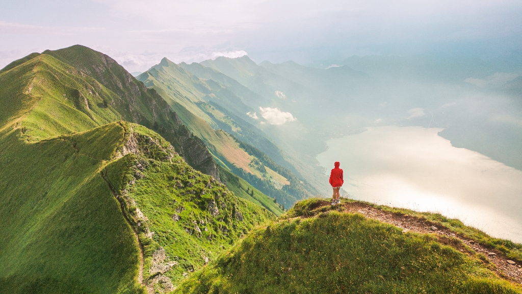 Frau mit roter Jacke auf dem Augstmatthorn – Sinnbild für Main Character Energy beim Reisen in den Schweizer Alpen