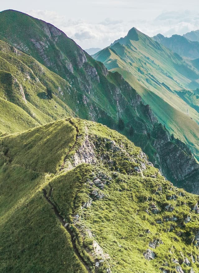 Main Character Energy Reisen Frau mit roter Jacke auf dem Augstmatthorn – Sinnbild für Main Character Energy beim Reisen in den Schweizer Alpen