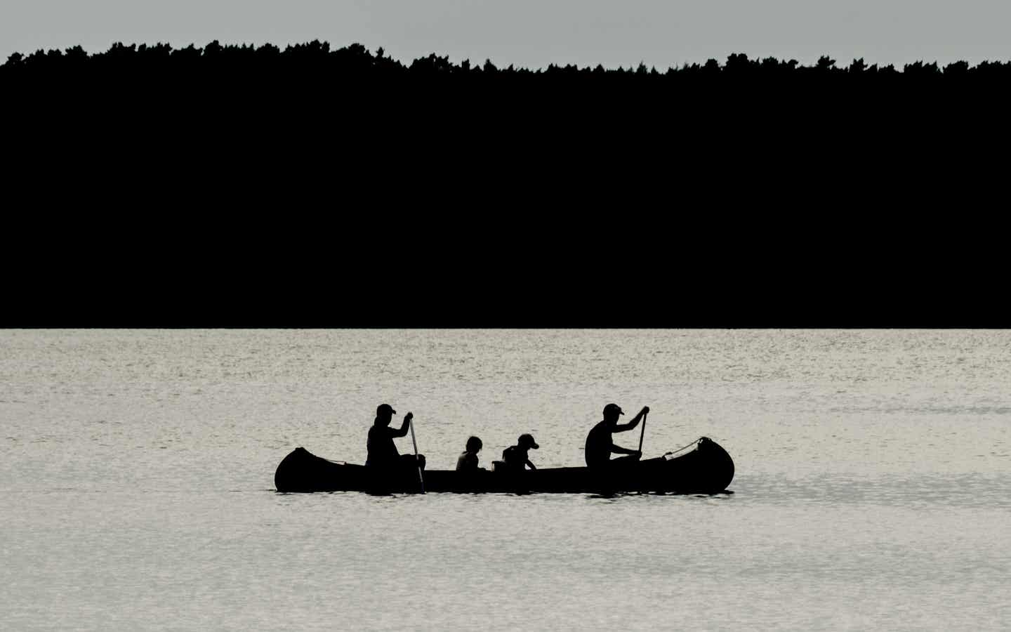 Mecklenburg Vorpommern Urlaub mit DERTOUR. Eltern mit zwei Kindern fahren mit Kanu über einen See