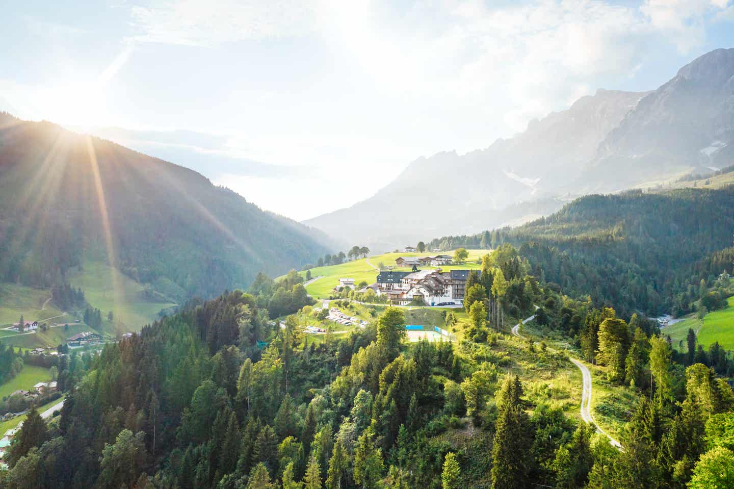 Blick auf das Hotel Aldiana Hochkönig in den Bergen bei strahlendem Sonnenschein