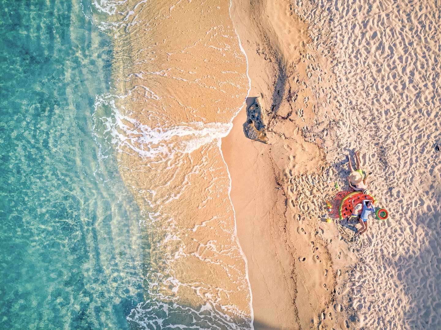 Familie am Sandstrand von Sithonia in Chalkidiki, Griechenland aus der Vogelperspektive 