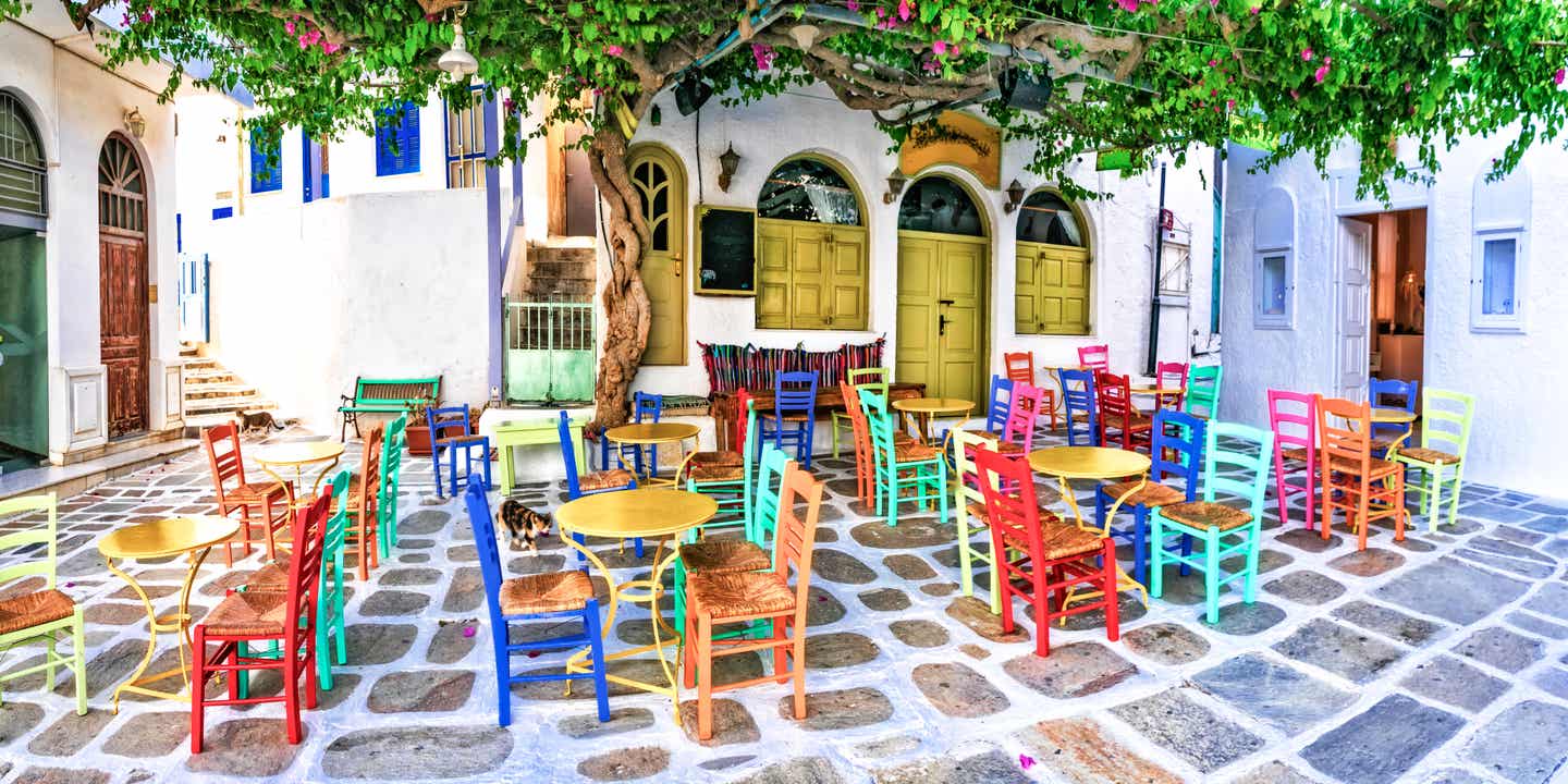 Blick auf bunte Stühle einer leeren Taverne die auf das abendliche Partyleben auf den griechischen Inseln wartet