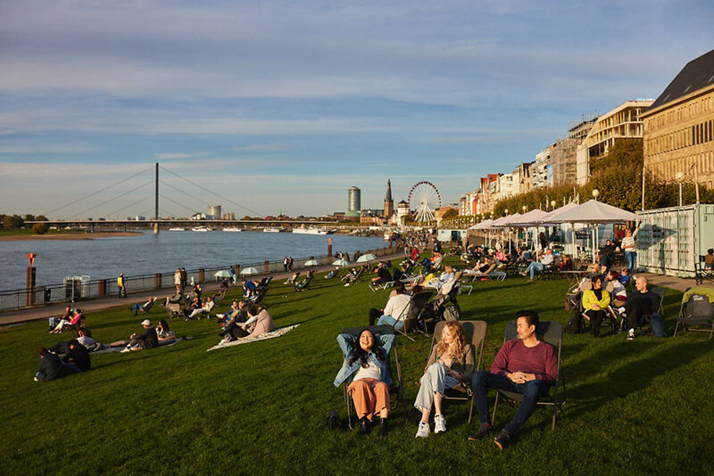 Stadtstrand mit vielen Personen am Flussufer in Düsseldorf