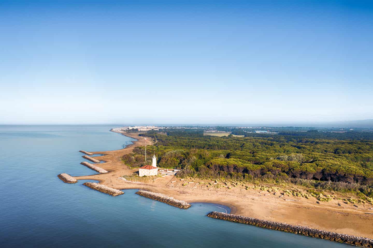 Bibione Urlaub mit DERTOUR. Blick über das Wasser der Lagune von Bibione mit italienischem Landhaus am Ufer